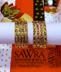 Two gold-plated bangle sets with intricate floral engravings displayed on a white cylindrical stand, with an orange and white SAWRA GOLD brand box in the background.
